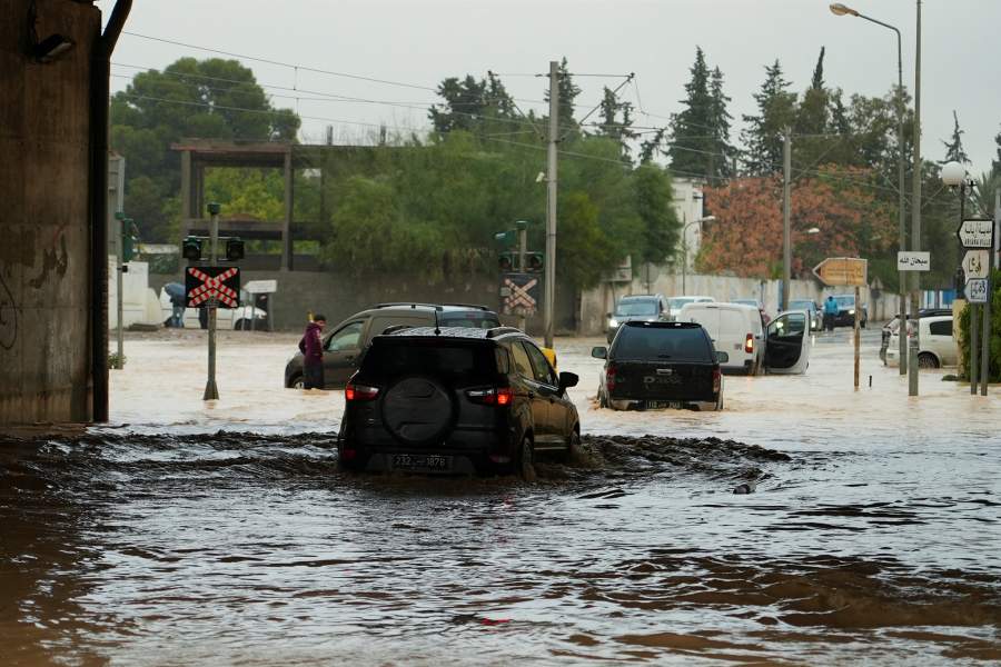 People and vehicles attempt to travel through flooded streets as torrential rains hit the country, in Tunis, Tunisia January 20, 2026