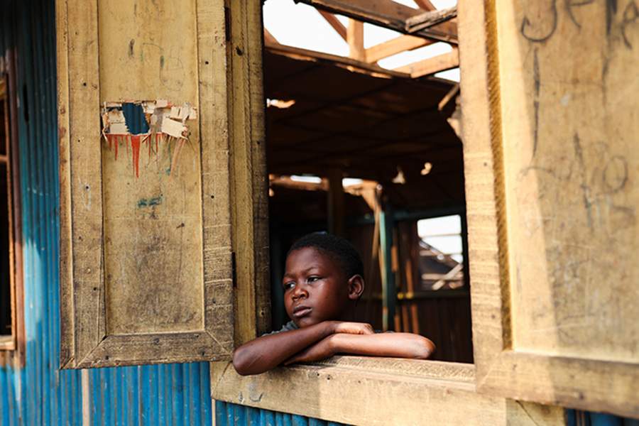 Prosper Atungbe, 7-year-old, looks out of a window in the Makoko riverine community after authorities demolished his school in Lagos, Nigeria, January 25, 2026. Officials are removing structures, including homes and schools, near power lines, in a wider push to recover lagoon side land from the historic fishing community often called the "Venice of Nigeria." REUTERS/Sodiq Adelakun