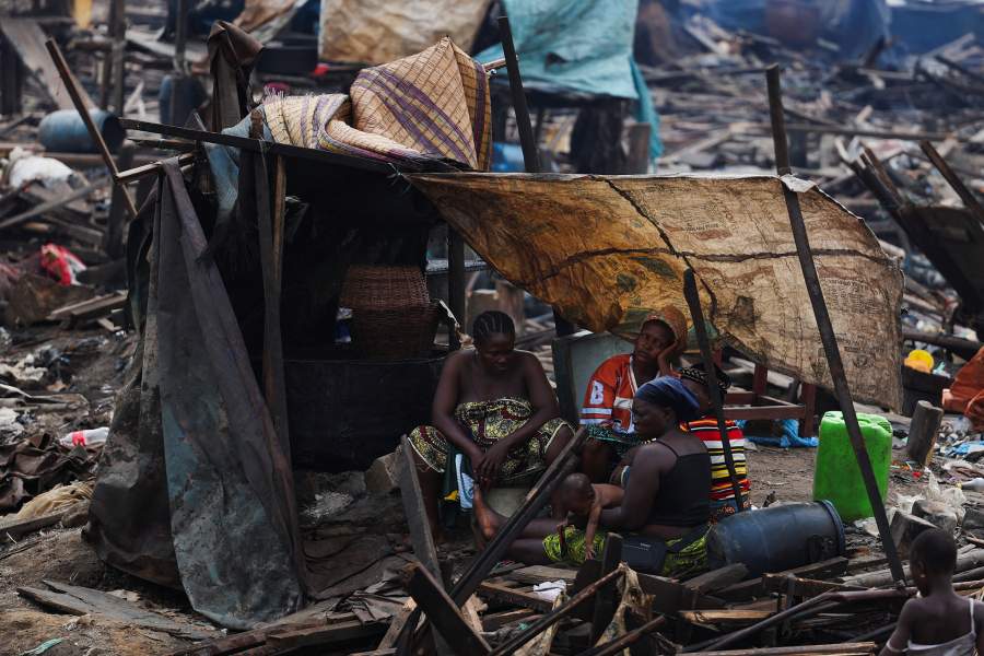 A family rests in a makeshift tent after authorities burn remaining structures in their Makoko riverine community in Lagos, Nigeria, January 25, 2026. Officials are removing structures, including homes and schools, near power lines, in a wider push to recover lagoon-side land from the historic fishing community often called the "Venice of Nigeria." REUTERS/Sodiq Adelakun