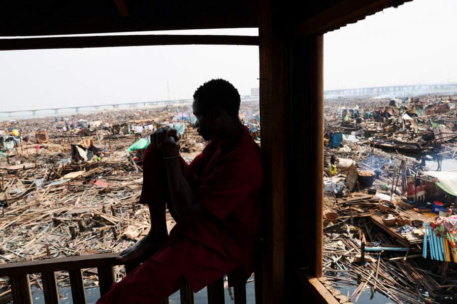 A person looks on as authorities burn remaining structures in Makoko riverine community in Lagos, Nigeria, January 25, 2026. Officials are removing structures, including homes and schools, near power lines, in a wider push to recover lagoon side land from the historic fishing community often called the "Venice of Nigeria." REUTERS/Sodiq Adelakun