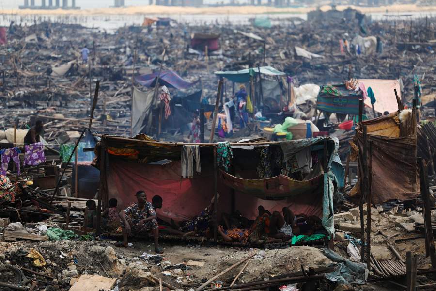 People rest inside a makeshift shelter as authorities burn remaining structures in the Makoko riverine community in Lagos, Nigeria, January 25, 2026. Officials are removing structures, including homes and schools, near power lines, in a wider push to recover lagoon-side land from the historic fishing community often called the "Venice of Nigeria." REUTERS/Sodiq Adelakun