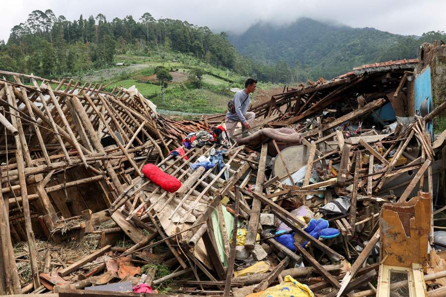 Ahmad Rohimat, 30, collects belongings from his damaged house following a landslide due to heavy rains in Pasir Langu village, West Bandung regency, West Java province, Indonesia, 
