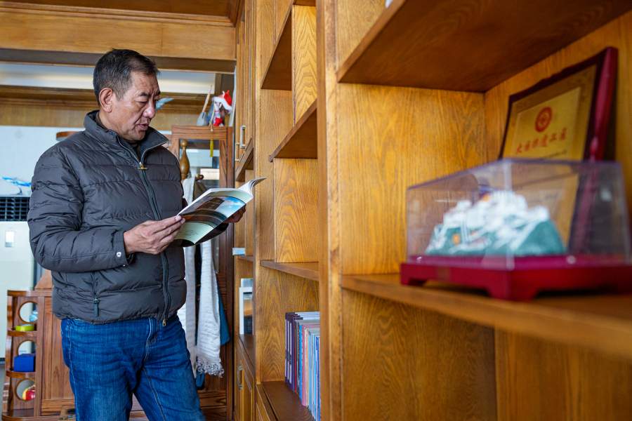 Норбу Сидар читает книги в своем кабинете в Сицзанской академии тханка в Лхасе, Сицзанский автономный район, юго-западный Кита