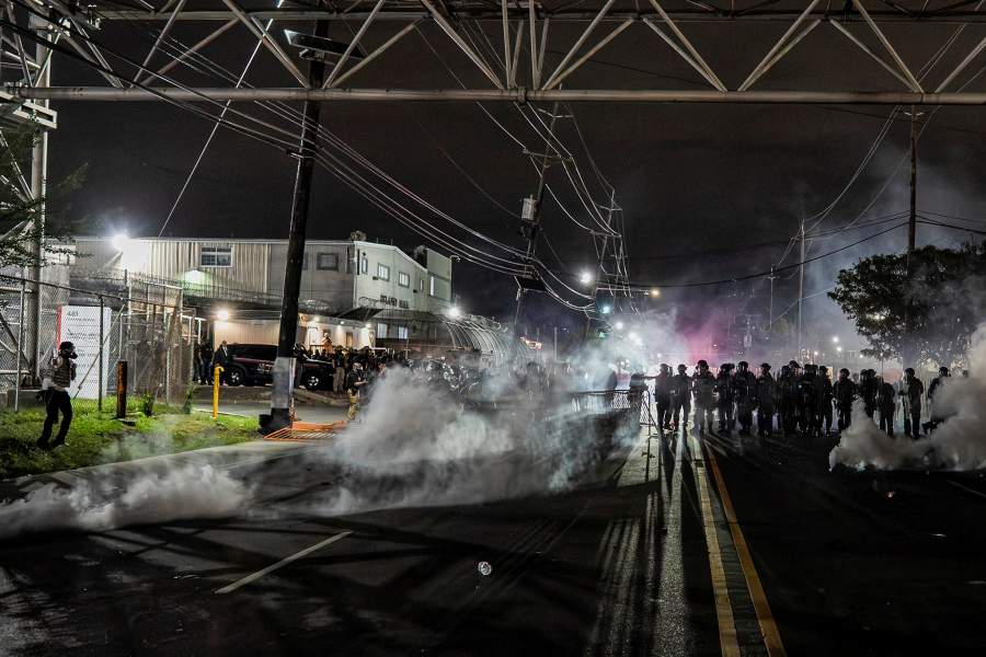 New Jersey State Policemen stand guard near the deployed tear gas as protestors remain gathered outside Delaney Hall detention center, in Newark, New Jersey, U.S