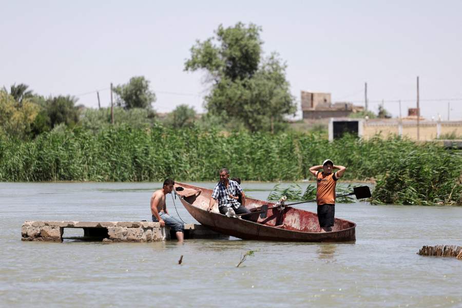 Residents use a boat due to rising water levels of the Euphrates River caused by increased dam releases following heavy rainfall this year, in Deir al-Zor, Syria, May 30,
