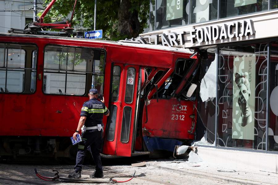 A police officer takes a photo of a tram that derailed and crashed into a commercial building injuring 12 people, in Belgrade, Serbia, May 25