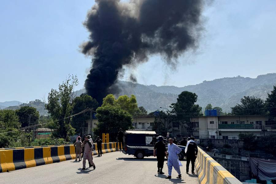 People and police gather nearby as smoke billows from the site where an Mi-17 helicopter of Pakistan Army Aviation crashed near Muzaffarabad, Pakistani Kashmir, June 10, 2026. Picture taken with a mobile phone. REUTERS/Tariq Maqbool TPX IMAGES OF THE DAY