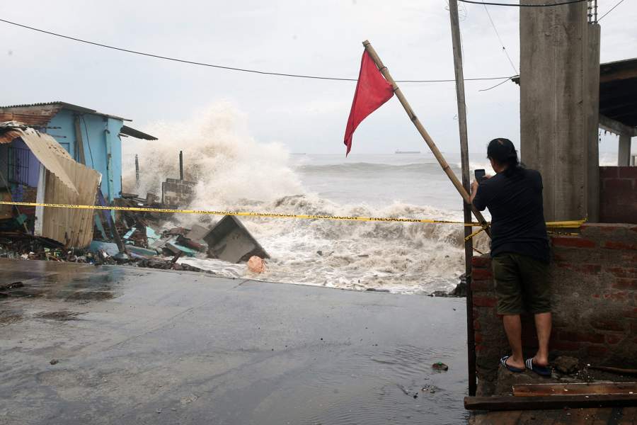 A man holds a cell phone as Tropical Depression Cristina approaches the coast in Acajutla, El Salvador, June 10, 2026. REUTERS/Jose Cabezas