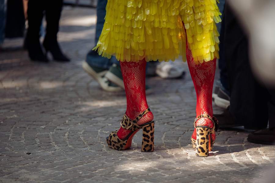  Street Style - Day 5 - Milan Fashion Week - Womenswear Spring/Summer 2027 MILAN, ITALY - SEPTEMBER 26: Chloe King wears red lace tights, yellow skirt and animal print brown platform heelsoutside Ferragamo show during the Milan Fashion Week - Womenswear Spring/Summer 2027 on September 26, 2026 in Milan, Italy