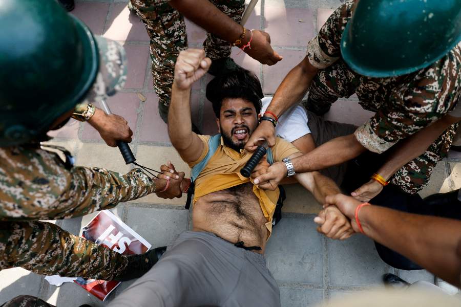 A protester gestures while being detained by security personnel during a protest by the Cockroach Janta Party (CJP) seeking the resignation of India's Chief Election Commissioner Gyanesh Kumar, near the protest site in New Delhi, India, 